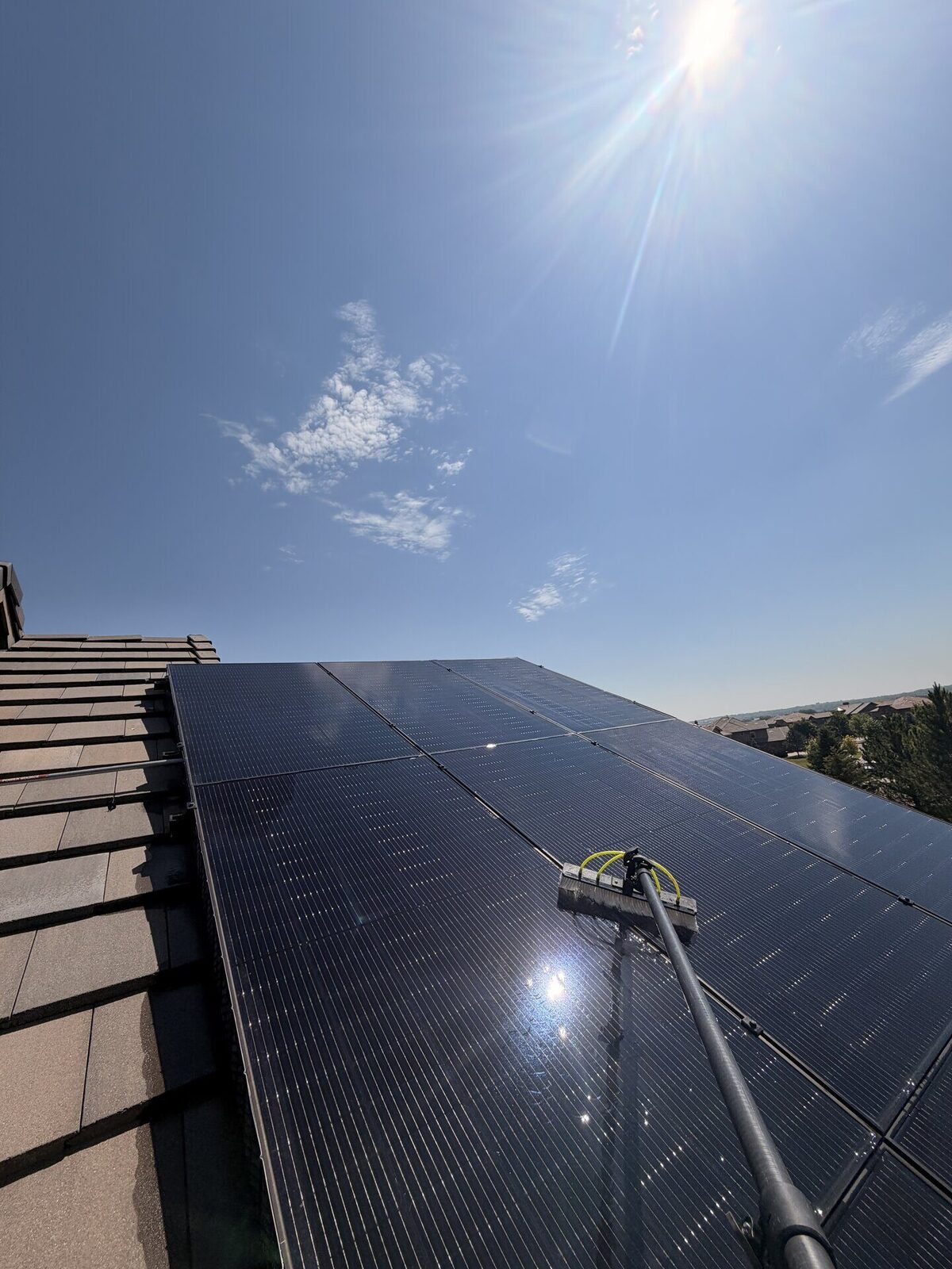 Solar panels being washed with a water-fed brush